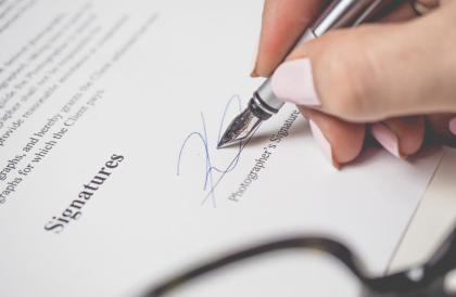 Image of signing a contract in ink, symbolizing the start of agency services and administrative work by Adarino